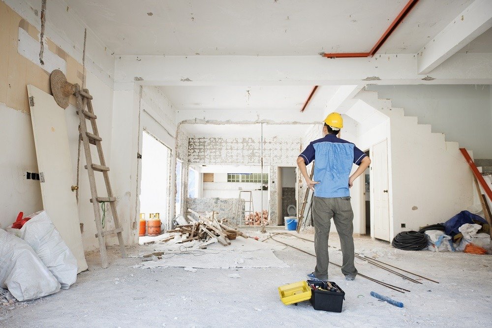 Contractor renovating a residential interior for professional window repair and installation as part of a home remodeling project.