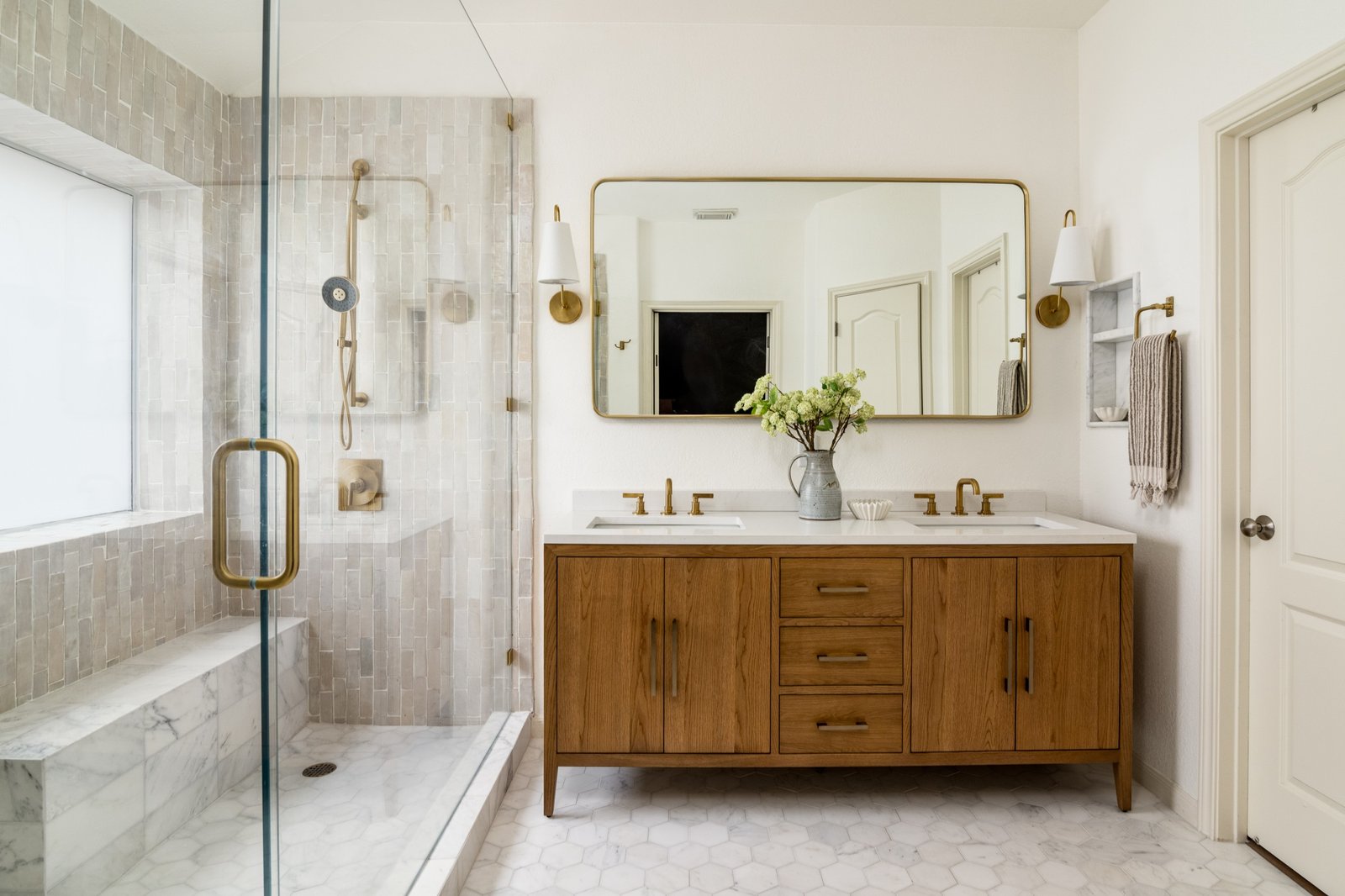 Modern bathroom remodeling with custom wood vanity, walk-in glass shower, and marble tile